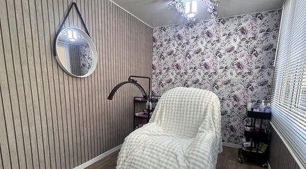 Cozy treatment room at Beauty By Yas, Attleborough, England, GB with floral wallpaper and comfy chair.