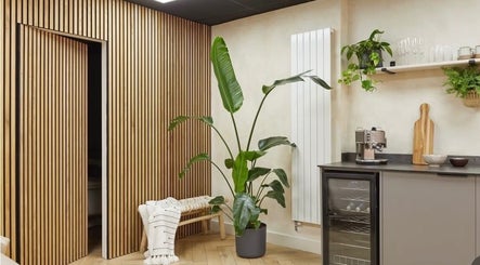 Relaxing space at Kenna Wellness & Spa in London, England, GB with plant and wooden decor.