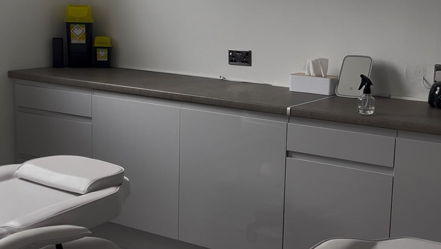 Modern treatment room at ByMara, Glasgow, Scotland, GB, featuring sleek cabinetry and comfortable seating.