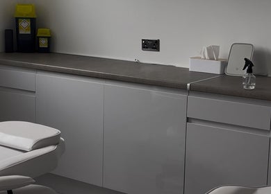 Modern treatment room at ByMara, Glasgow, Scotland, GB, featuring sleek cabinetry and comfortable seating.