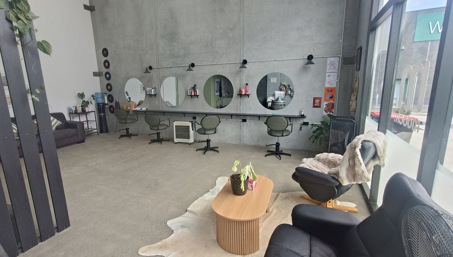 Ātahu Hair salon in Wellington offers a chic, modern setting with stylish seating and decor for a relaxing experience.
