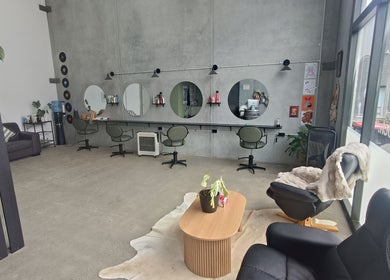 Ātahu Hair salon in Wellington offers a chic, modern setting with stylish seating and decor for a relaxing experience.