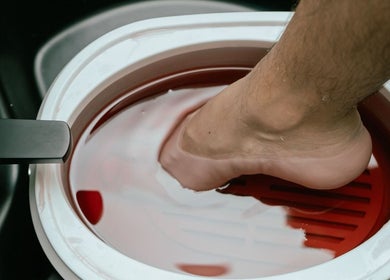 Pedicura relajante en 41.10 Nails Studio, Tulum, Quintana Roo, MX. Pie sumergido en un baño terapéutico.