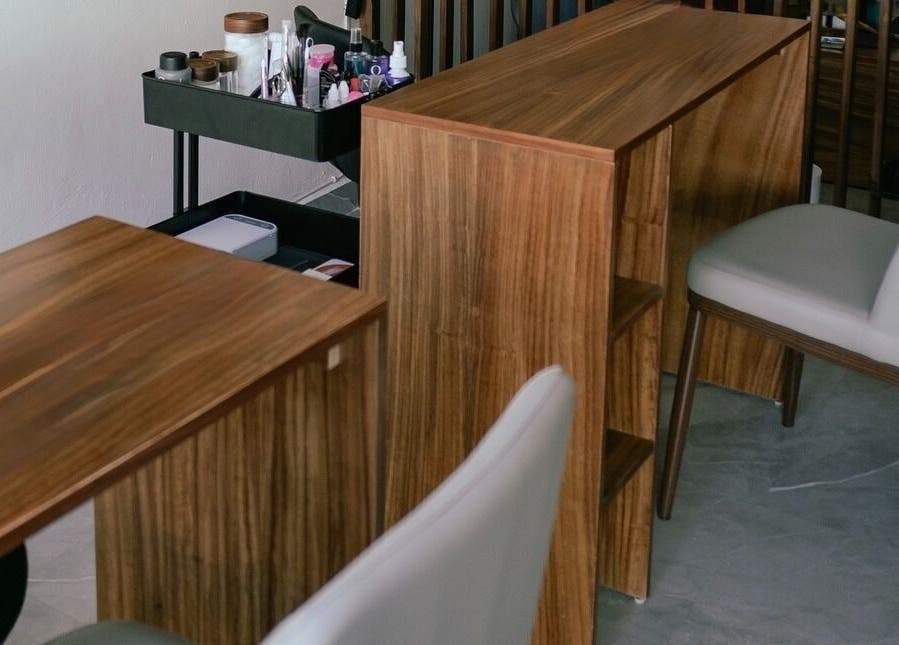 Mesa de manicura en 41.10 Nails Studio, Tulum, Quintana Roo, MX, con sillas modernas y herramientas de belleza.