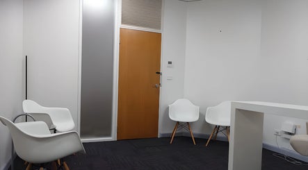 Relaxing waiting area at Balancing Wellness, Melbourne, Victoria, AU with modern white chairs and a minimalist design.