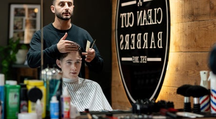 Barber at Clean Cut Barbers in Caringbah South, NSW, AU styling a client's hair with focused attention.