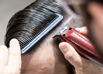 Close-up of a barber trimming hair at Clean Cut Barbers, Caringbah South, New South Wales, AU.