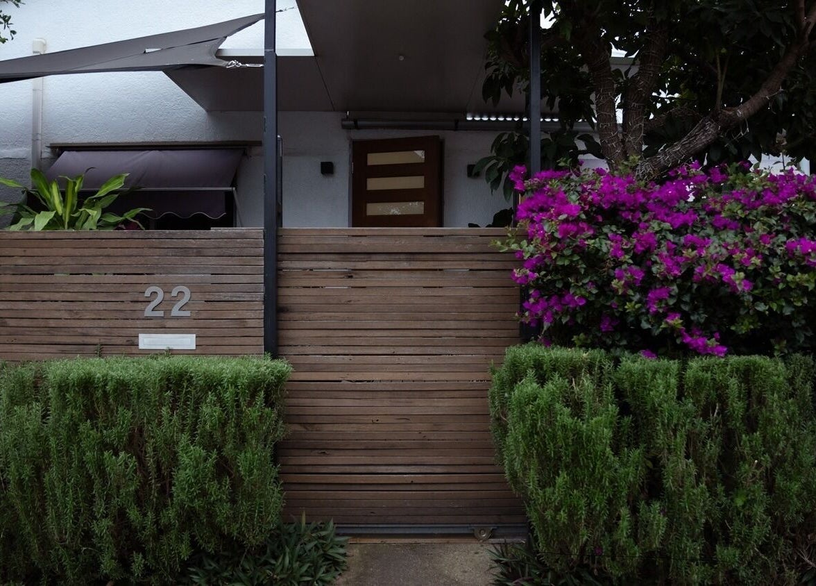Entrance of Gorgeous Lashes by Thuy, West End, Queensland, AU, framed by vibrant greenery and flowers.
