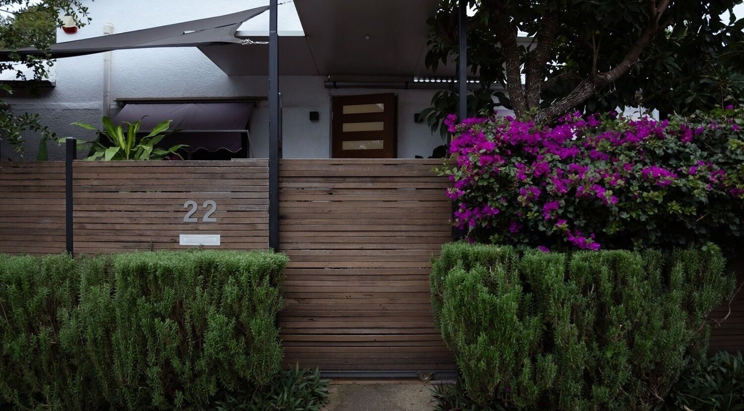 Entrance of Gorgeous Lashes by Thuy, West End, Queensland, AU, framed by vibrant greenery and flowers.