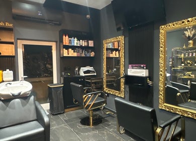 Elegant salon interior at Vogue & Volume, Il-ħamrun, MT, featuring gold mirrors and chic styling chairs.
