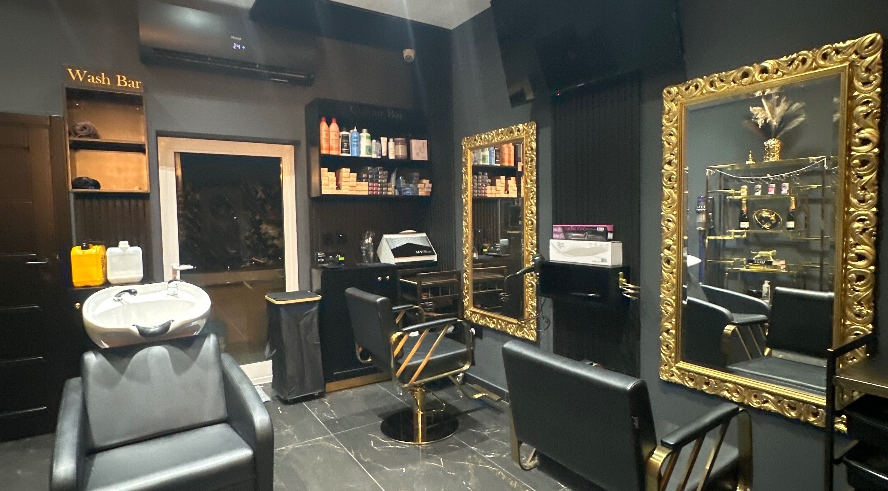 Elegant salon interior at Vogue & Volume, Il-ħamrun, MT, featuring gold mirrors and chic styling chairs.