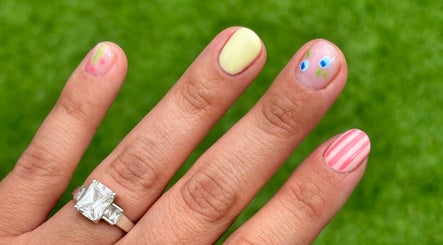 Unique manicure design at The Nail Babe in Bromley, England, GB with colorful and striped nail art.
