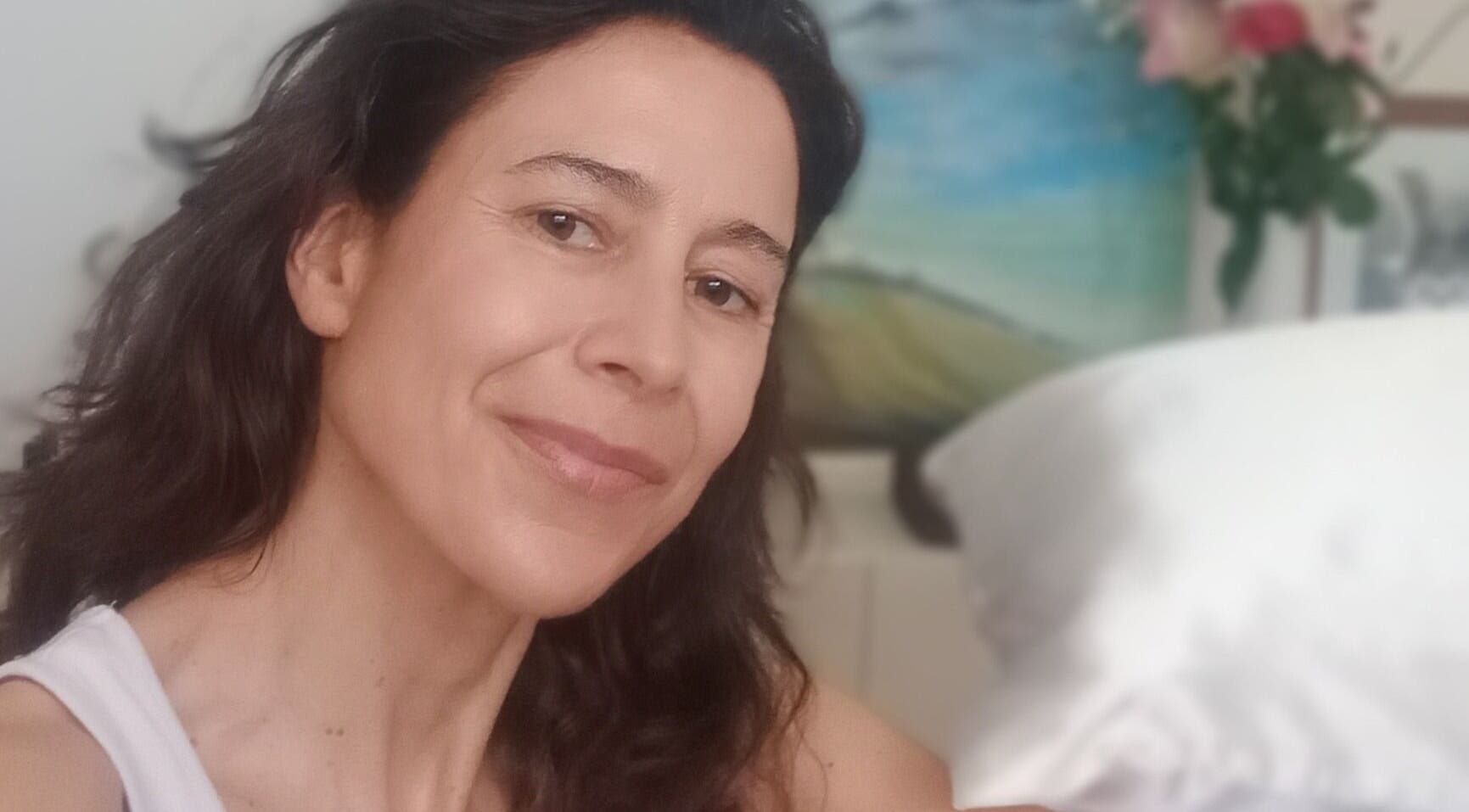 Relaxed woman smiling at Melt Massage, Royal Leamington Spa, England, GB with cozy ambiance.