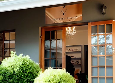 Charming exterior of Unfading Beauty in Gqeberha, Eastern Cape, ZA, featuring wooden doors and lush greenery.