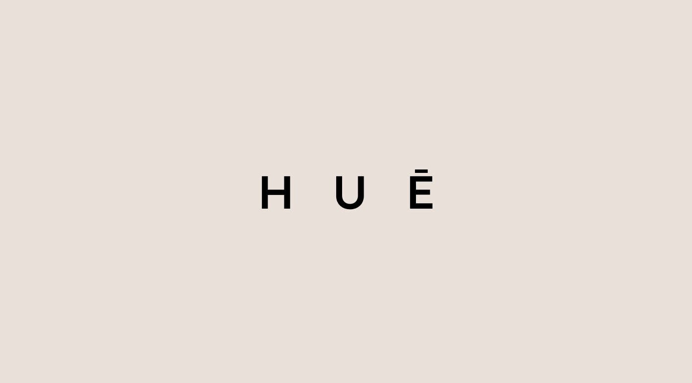 HUĒ logo on a beige background, representing the wellness venue in London, England, GB.