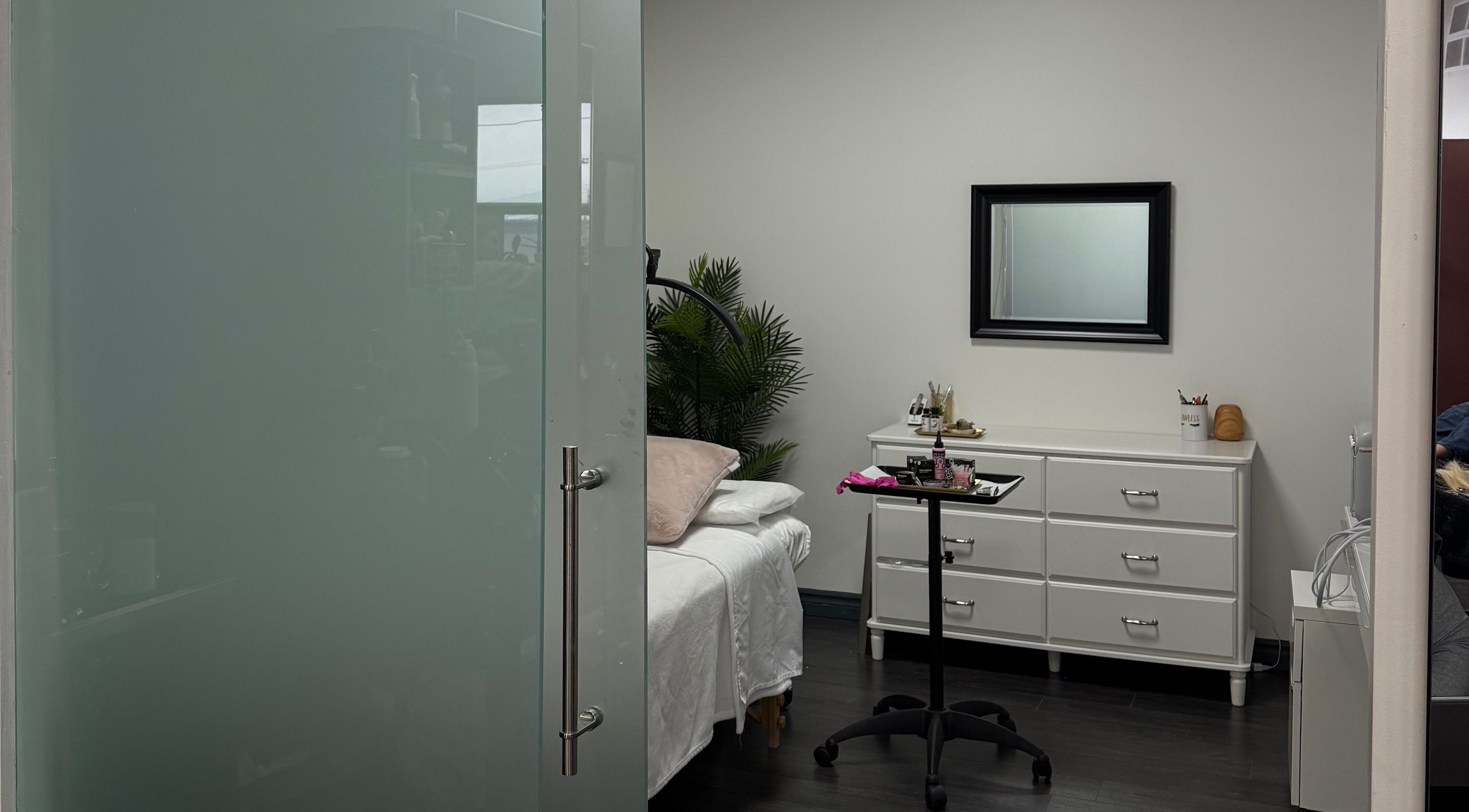 A tranquil treatment room at The Powder Room Mtl in Mont-royal, Québec, CA, featuring a bed and dresser.
