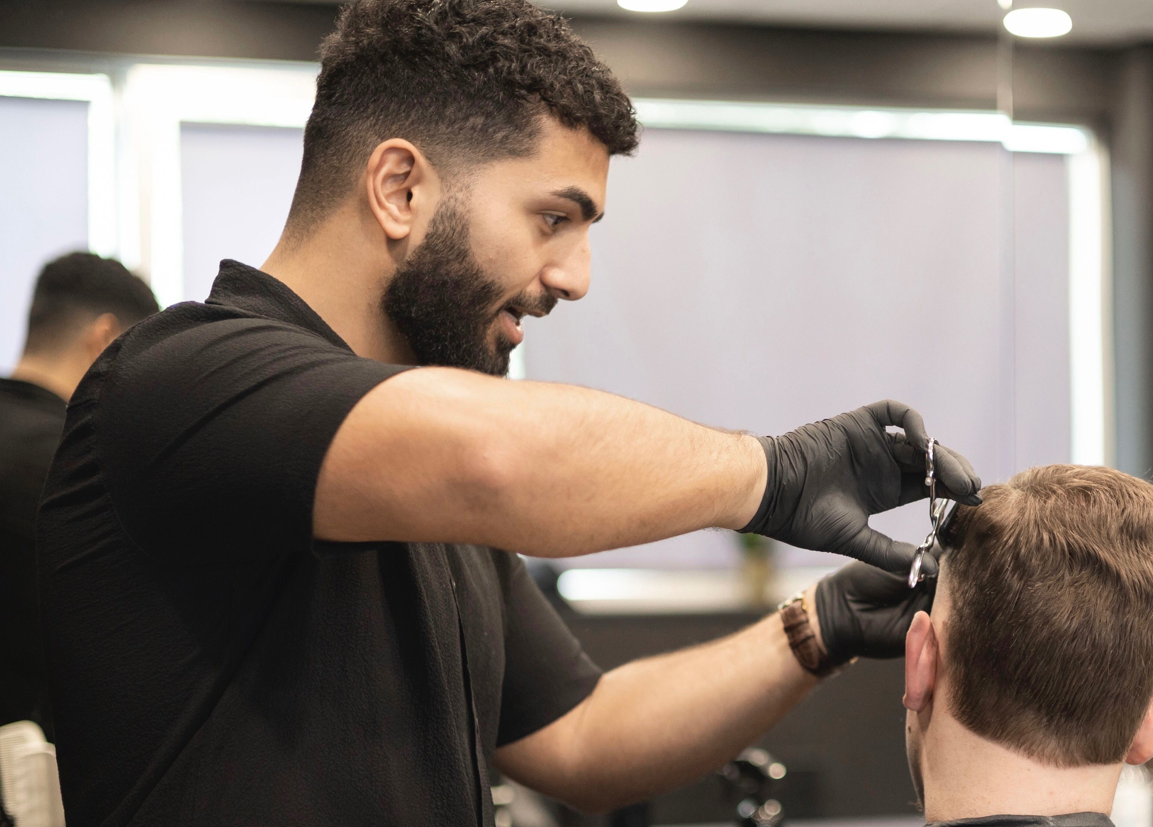 Kapster aan het werk bij Vision Barbershop in Assendelft, Noord-Holland, NL, levert precisiehaarstyling.