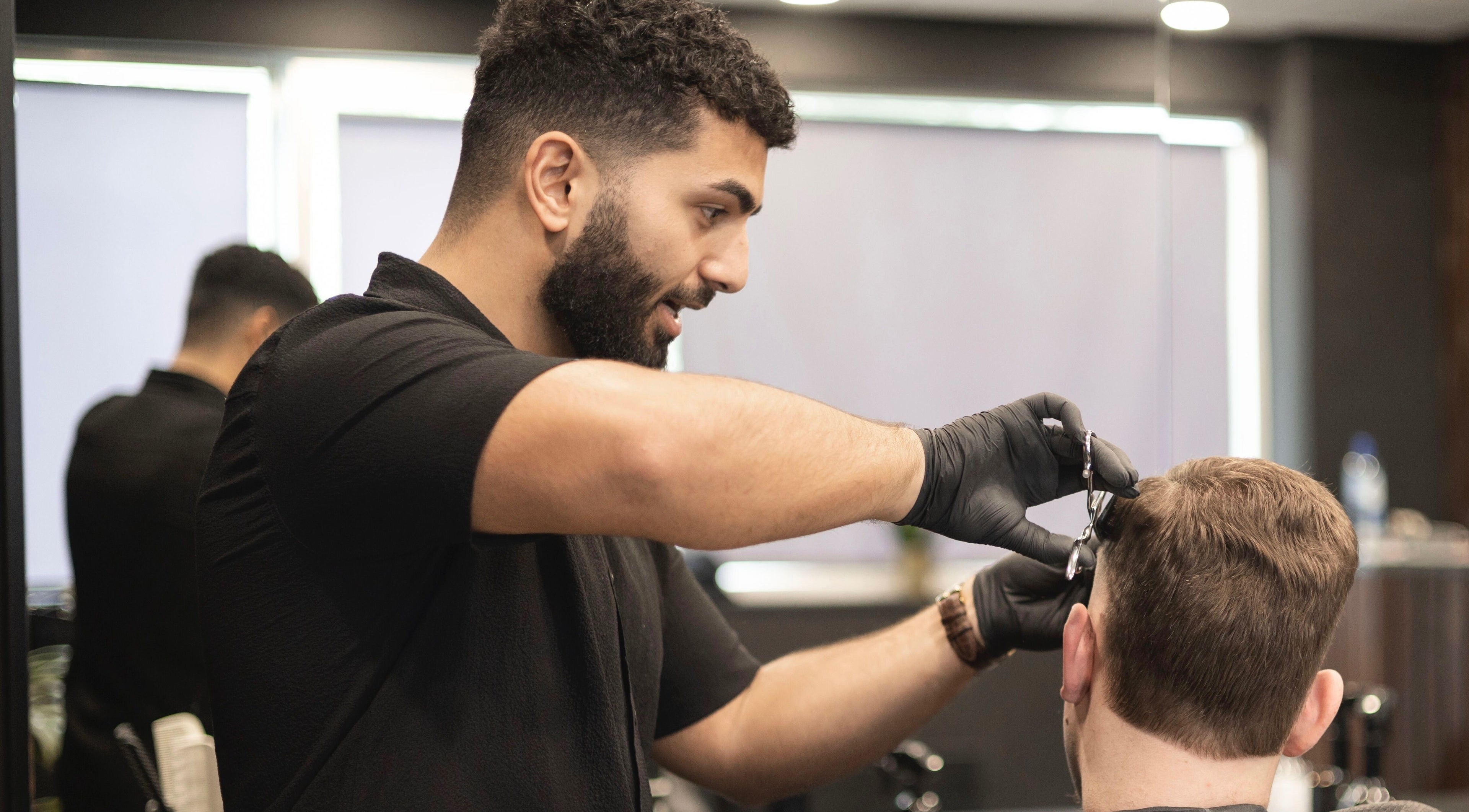 Kapster aan het werk bij Vision Barbershop in Assendelft, Noord-Holland, NL, levert precisiehaarstyling.