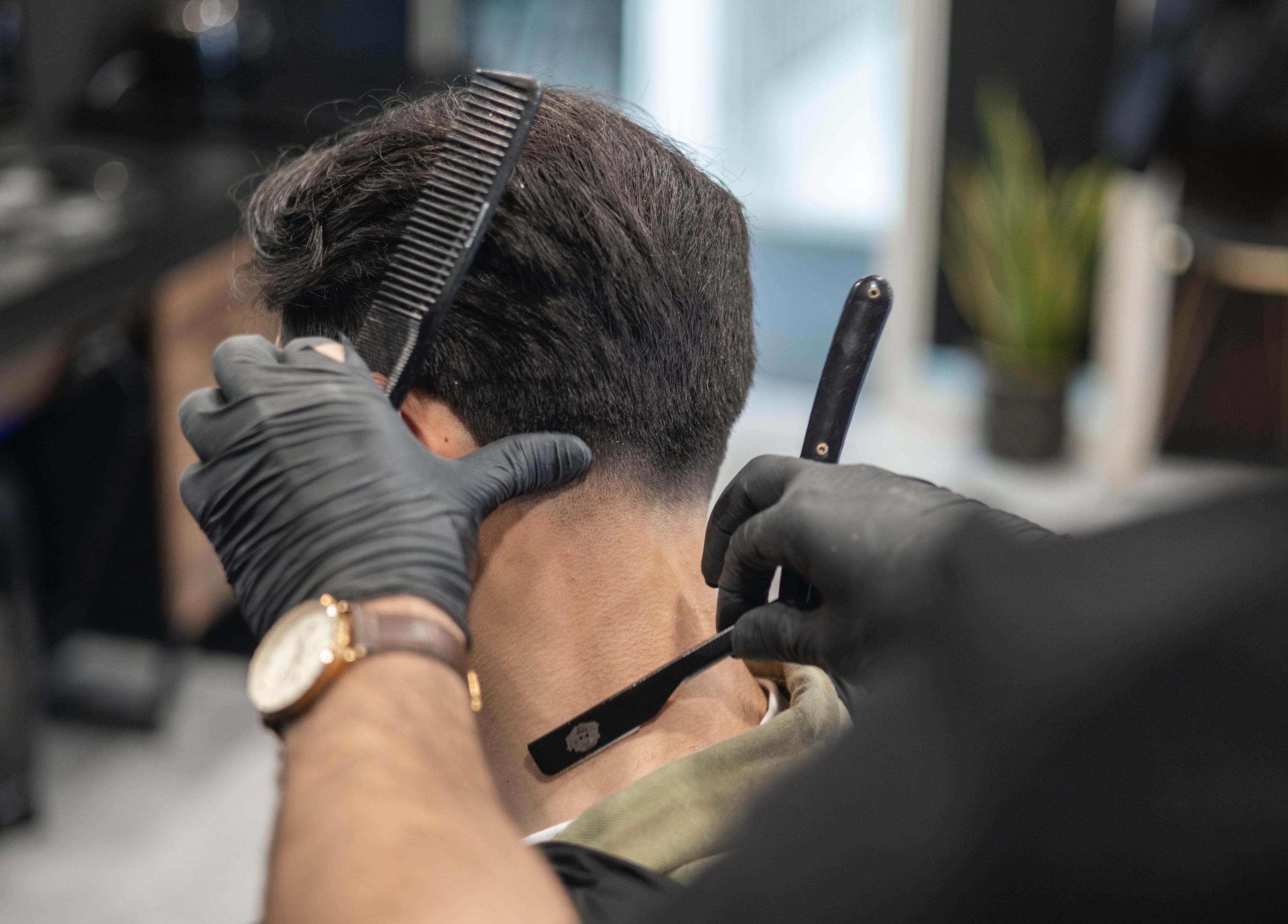 Professionele knipbeurt bij Vision Barbershop, Assendelft, Noord-holland, NL, met scheermes en kam.