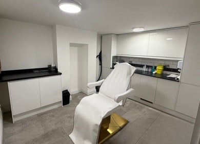 Modern treatment room at Allure Skin & Aesthetics in Sittingbourne, England, GB with a pristine chair and cabinets.