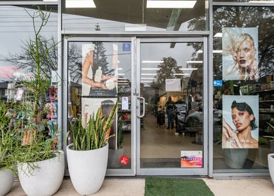 Entrance of ATSI Hair Supplies, Brookvale, NSW, showcasing stylish posters and vibrant greenery.