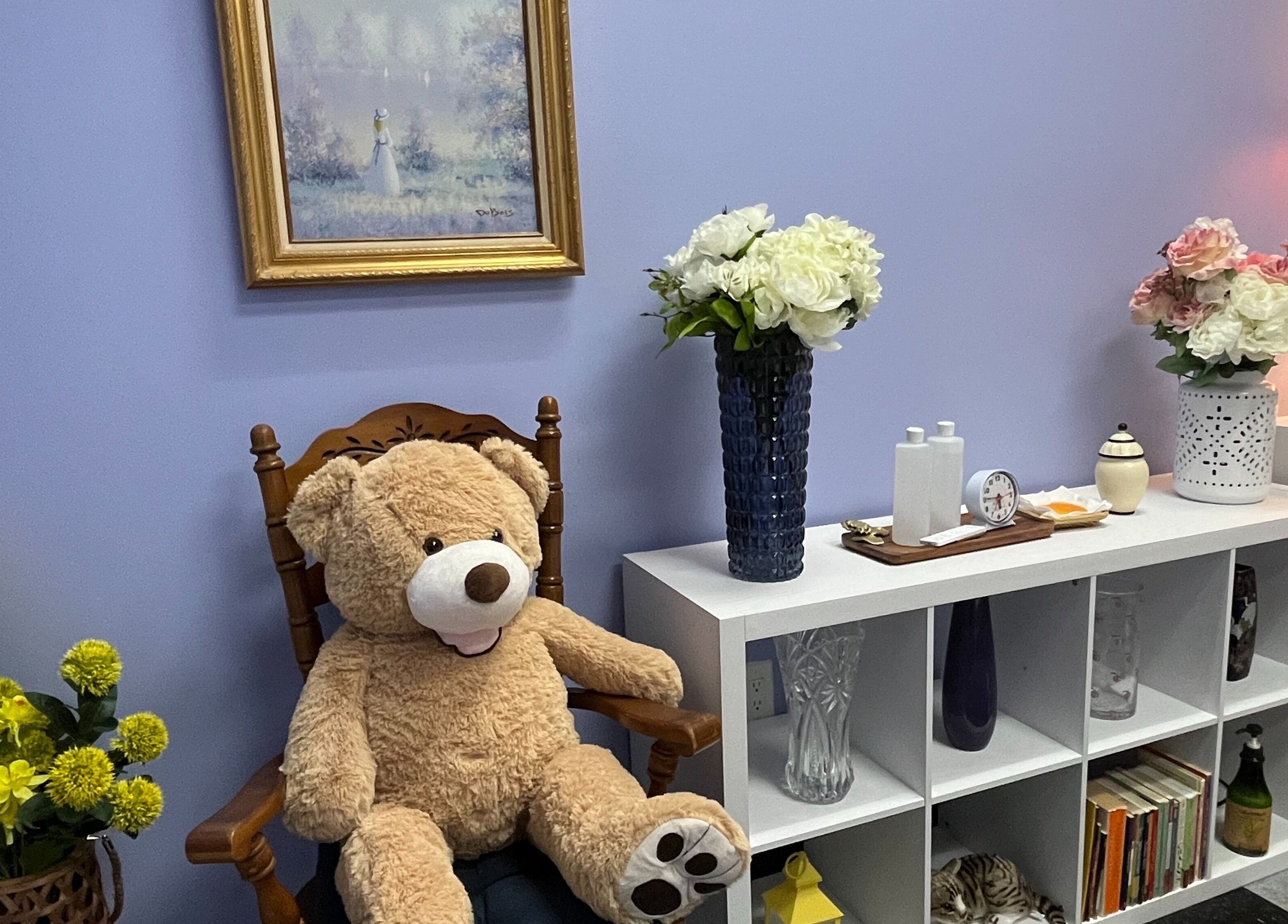 A welcoming corner at Emma's Sunflower Spa in New Windsor, New York, US with floral decor and a plush teddy bear.