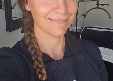 E R Beauty Therapy therapist in Plymouth, England, GB, smiling in a relaxing treatment room.