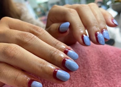 Manicura moderna en Desy Nails & Beauty, Bali, Bali, ID con uñas azul y bordes rojos.