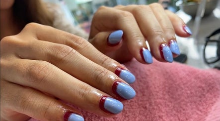 Manicura moderna en Desy Nails & Beauty, Bali, Bali, ID con uñas azul y bordes rojos.