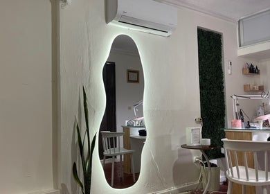 Interior moderno de Anlly Nail Studio en San Francisco De Macorís, Duarte, DO, con espejo iluminado y estación de trabajo.