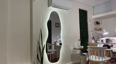 Interior moderno de Anlly Nail Studio en San Francisco De Macorís, Duarte, DO, con espejo iluminado y estación de trabajo.
