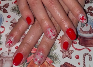 Elegante manicura navideña en Pretty & Bright, Lleida, Catalunya, ES con detalles de lazo y caramelo.