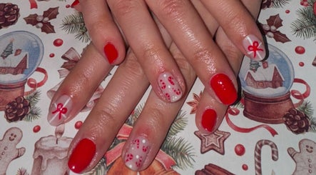 Elegante manicura navideña en Pretty & Bright, Lleida, Catalunya, ES con detalles de lazo y caramelo.