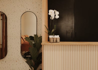Reception area of BTS Beauty, Centurion, Gauteng, ZA with orchids and mirrors.