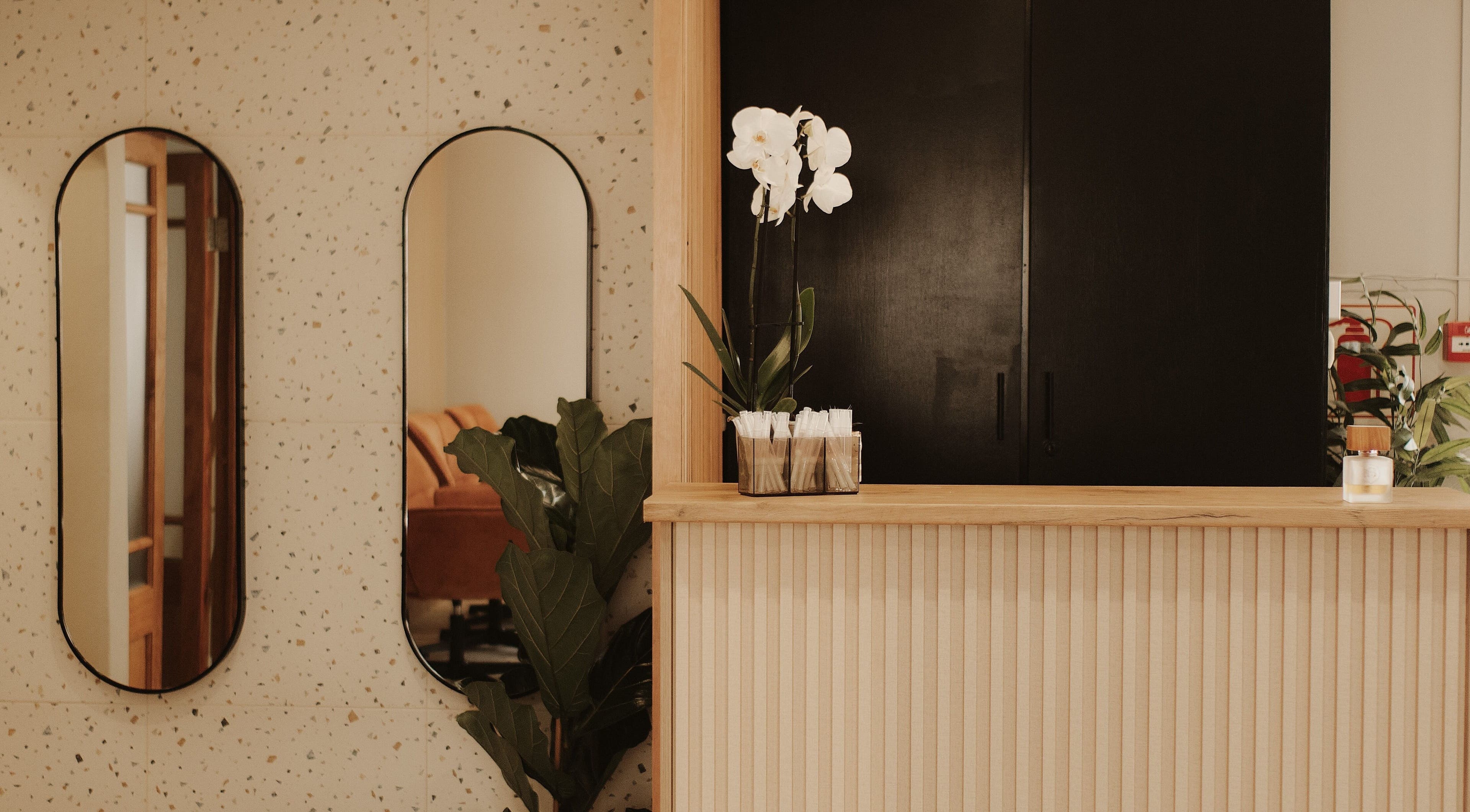 Reception area of BTS Beauty, Centurion, Gauteng, ZA with orchids and mirrors.