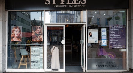 Ana Wellbeing salon in Luton, England. Stylish glass facade with vibrant hair posters and modern decor.