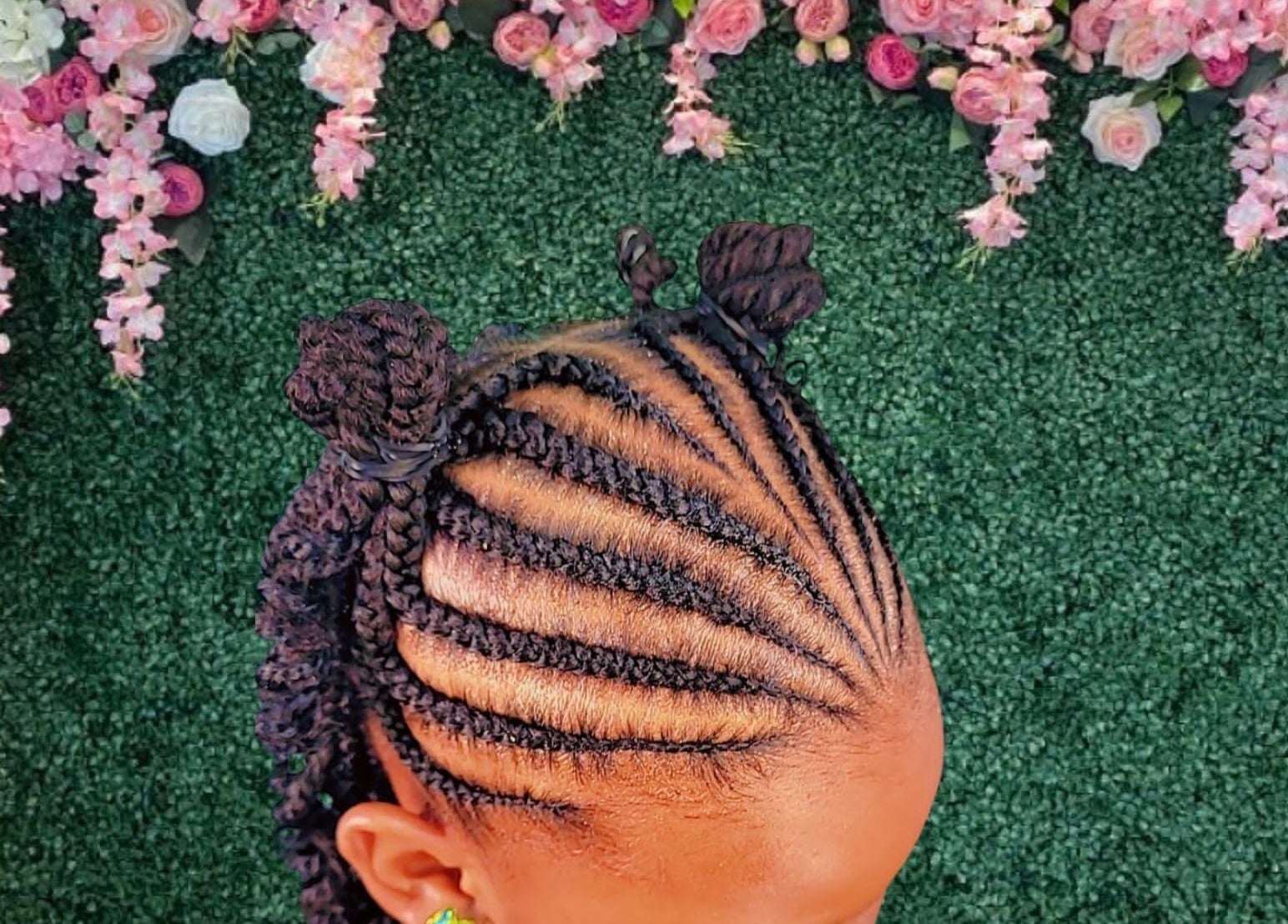 Intricate braided hairstyle with floral backdrop at The Mane & Tame Haven, Dieppe Bay, KN.