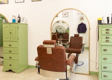 Vintage barber chair at Jacobs Perry Road, Bristol, England, GB with green cabinets and mirrors.
