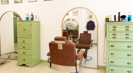 Vintage barber chair at Jacobs Perry Road, Bristol, England, GB with green cabinets and mirrors.