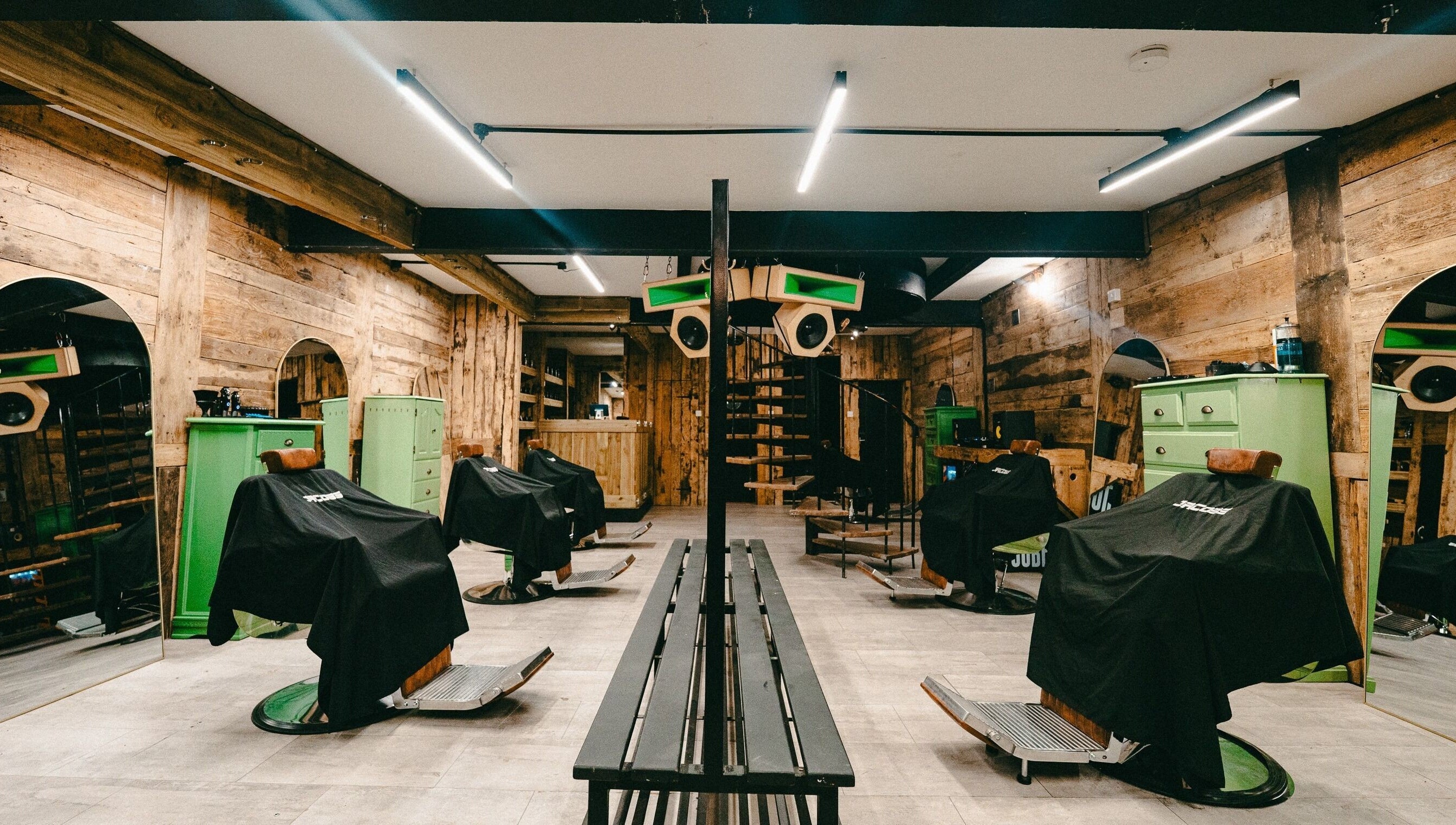 Rustic interior of Jacobs Park Street in Bristol, England, GB showcasing stylish green barber chairs.