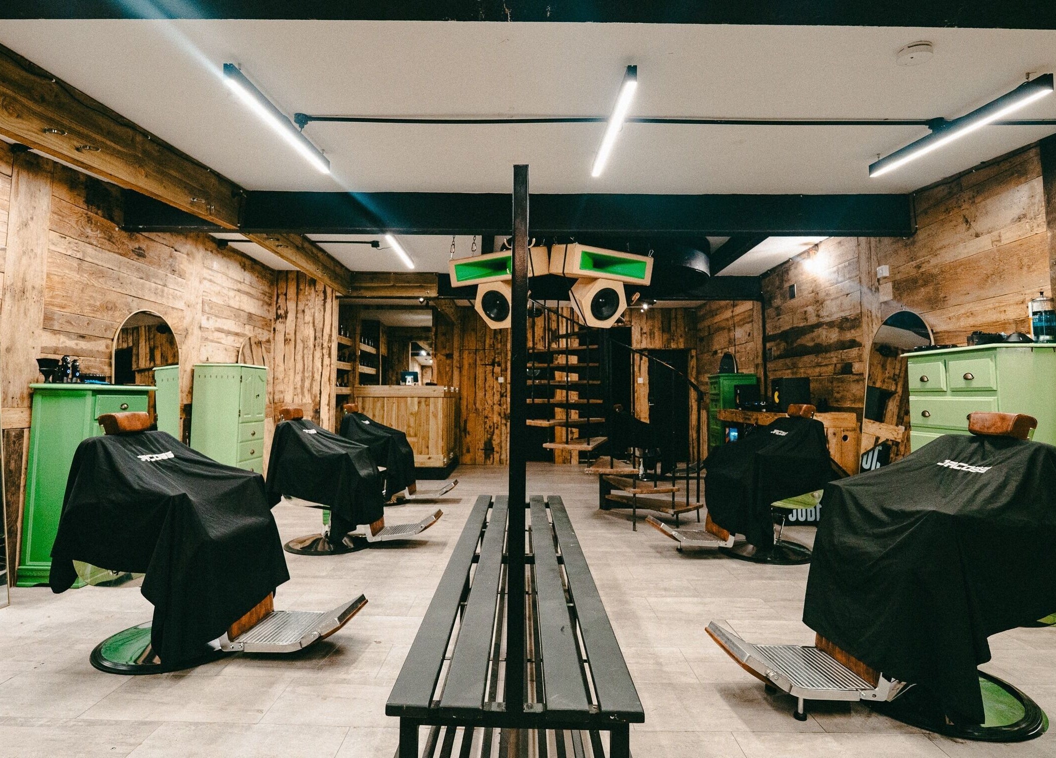 Rustic interior of Jacobs Park Street in Bristol, England, GB showcasing stylish green barber chairs.