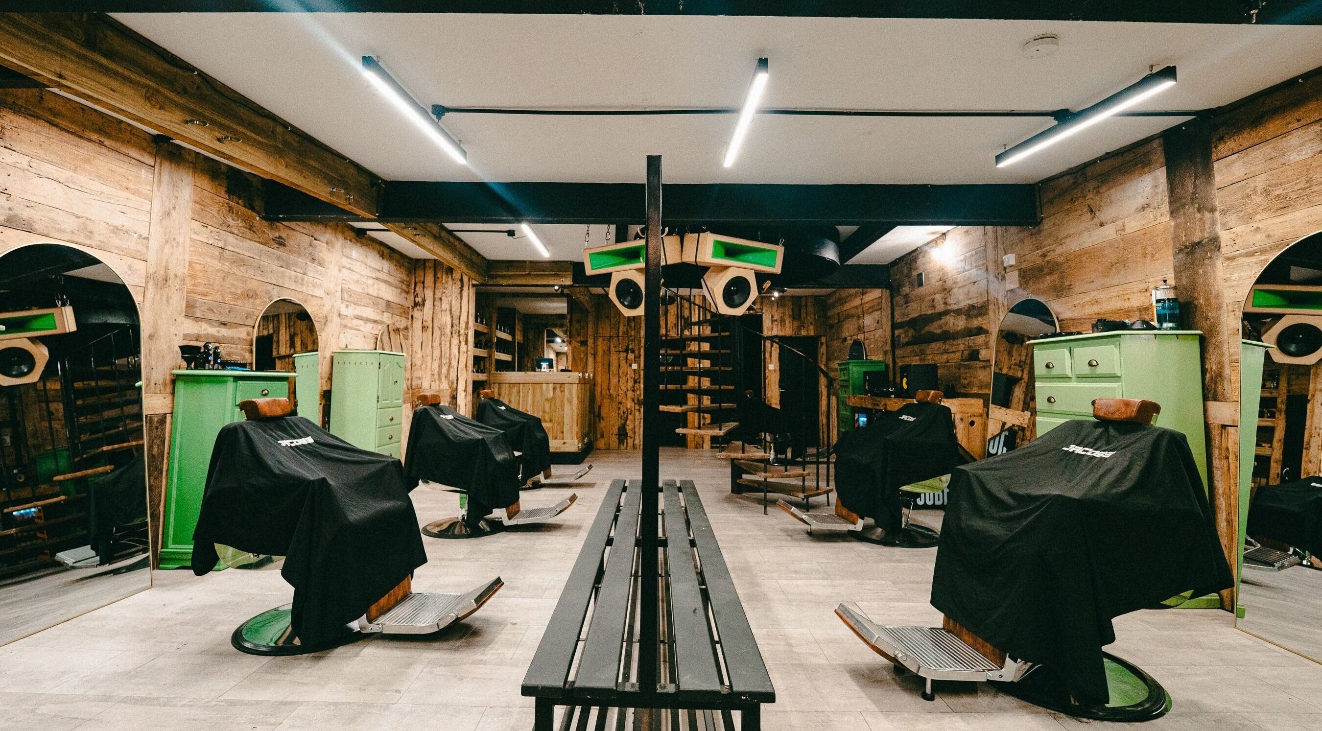 Rustic interior of Jacobs Park Street in Bristol, England, GB showcasing stylish green barber chairs.