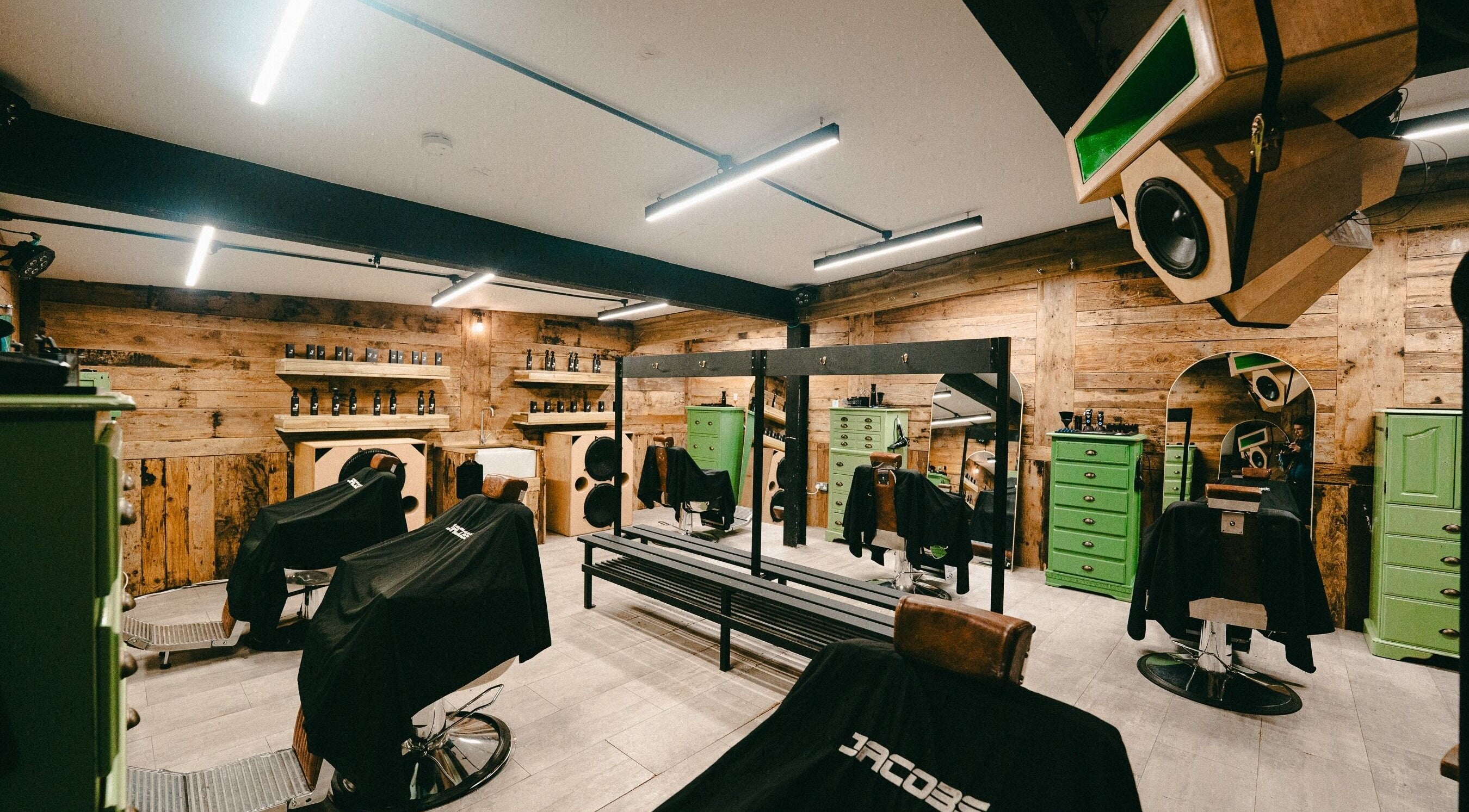 Interior of Jacobs Park Street barbershop in Bristol, England with rustic wood decor and modern styling chairs.