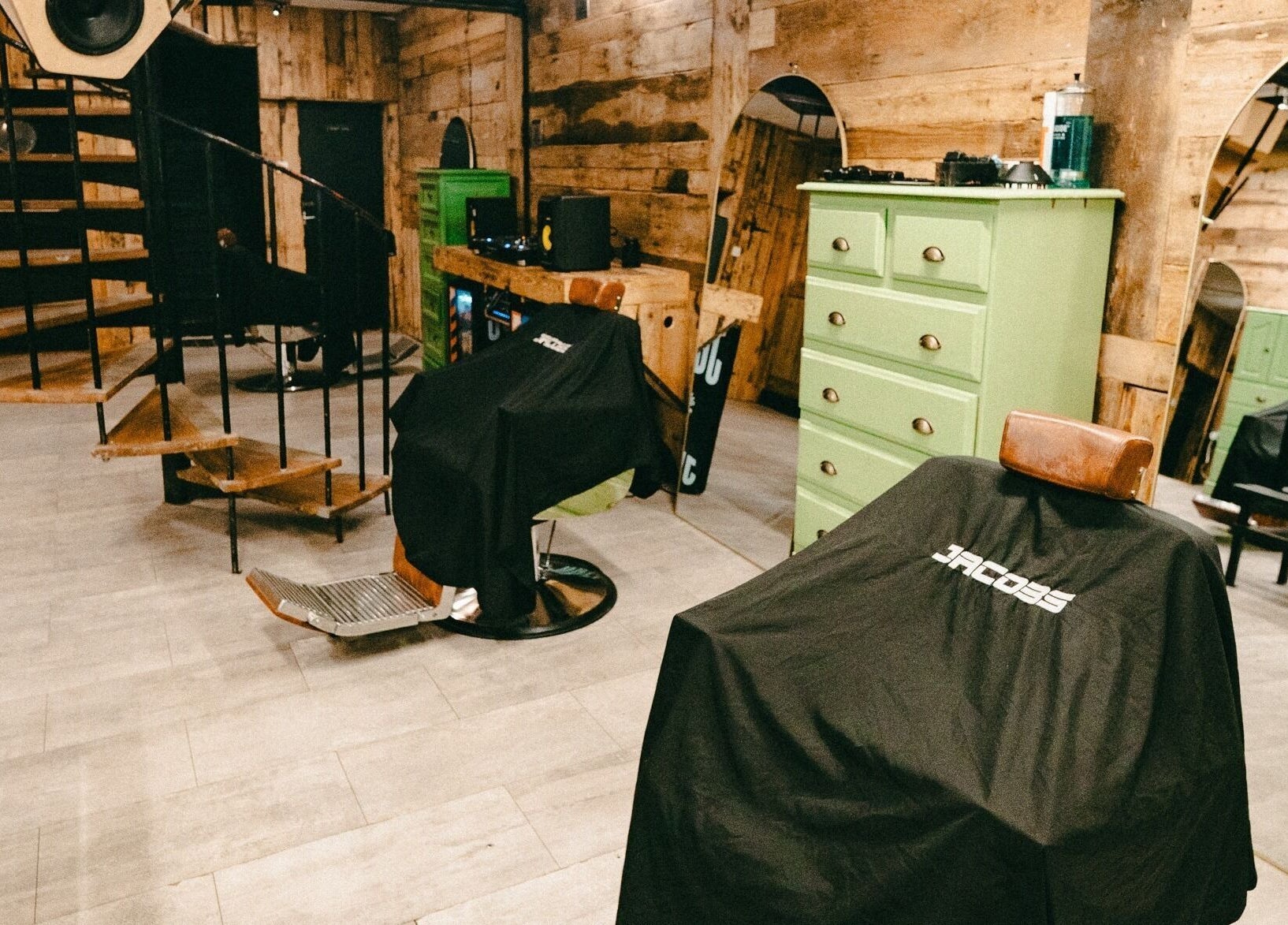 Interior view of Jacobs Park Street salon in Bristol, England, GB showcasing spiral staircase and barber chairs.