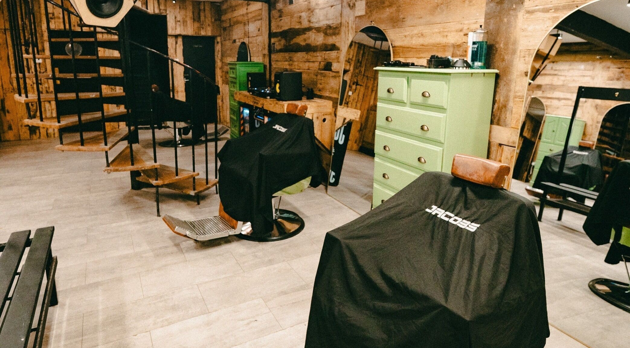 Interior view of Jacobs Park Street salon in Bristol, England, GB showcasing spiral staircase and barber chairs.