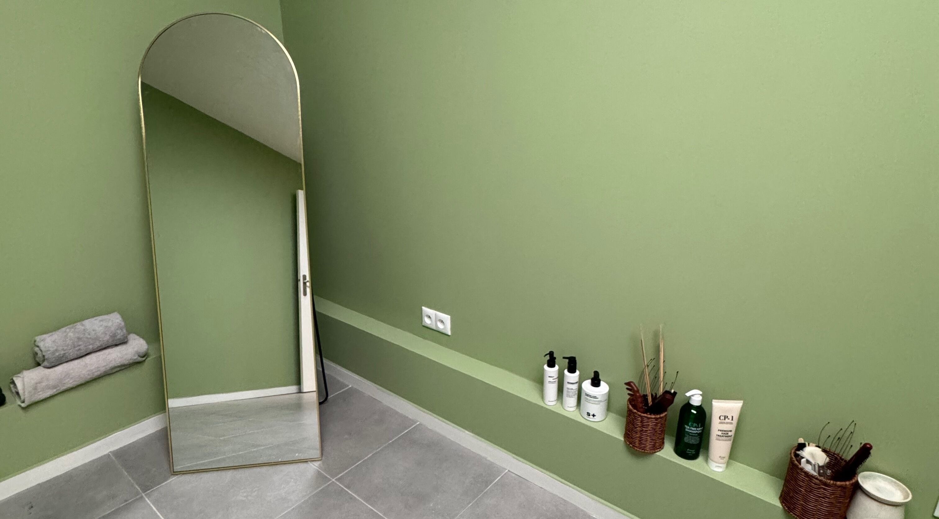 Minimalist room with green walls and mirror at HASOKA institut, Chelles, Île-de-france, FR.