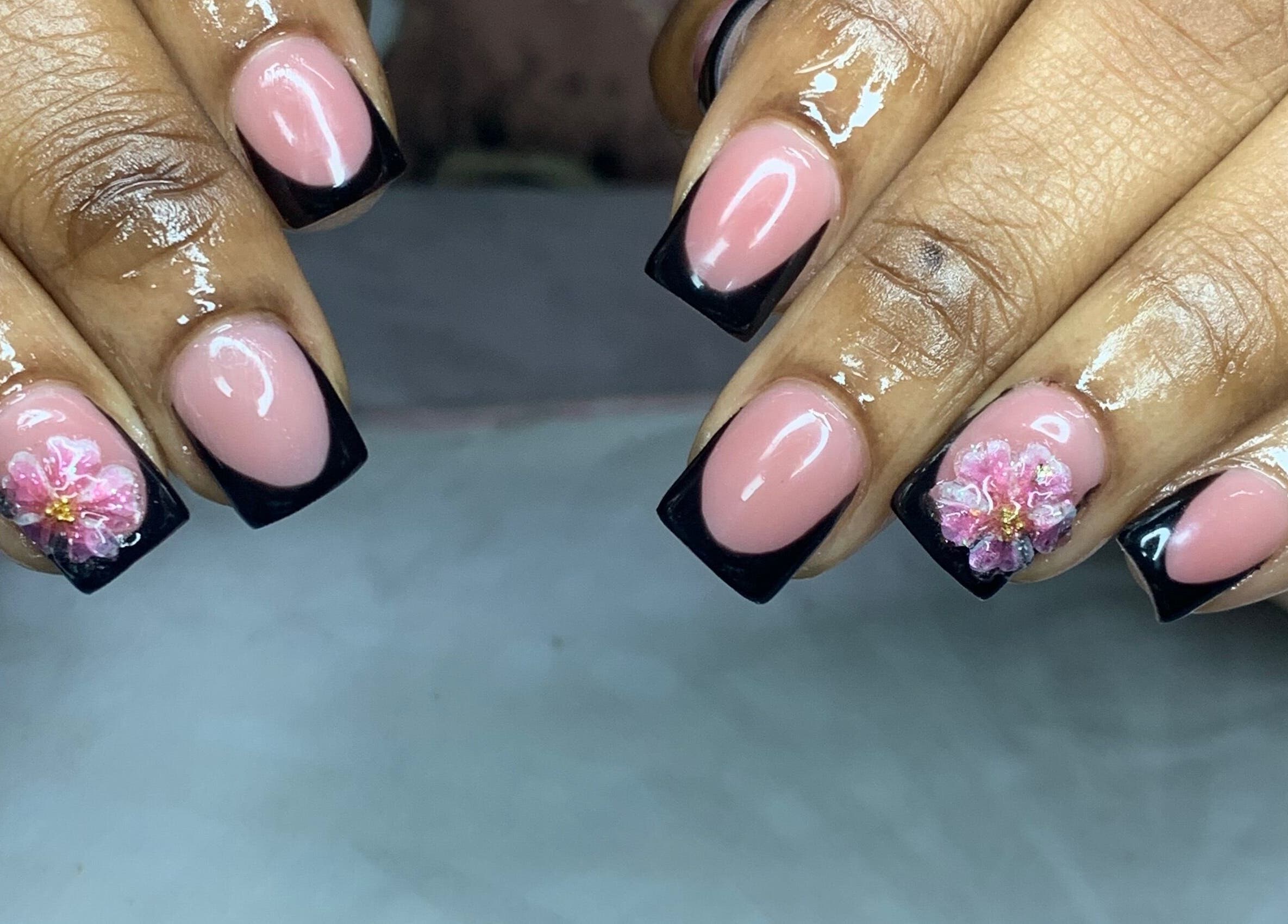 Elegant nails with black French tips and flower art at Venomcave, Paramaribo, Paramaribo, SR.
