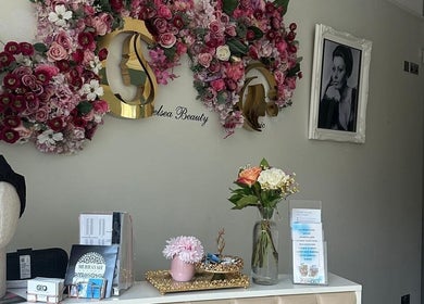 Floura Clinic's elegant reception in London, England, GB adorned with floral decor and beauty products.