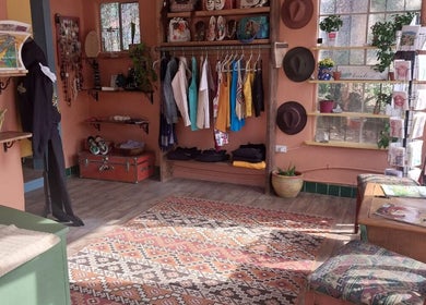 Quaint interior of Hair By Tina in Questa, New Mexico, US, showcasing vibrant clothing and accessories.