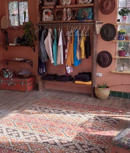 Quaint interior of Hair By Tina in Questa, New Mexico, US, showcasing vibrant clothing and accessories.